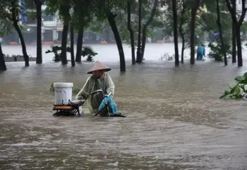 A bike rider moving through a flooded street. Photo: Tung X Ngo/IRIN