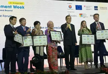 The panellists stand on stage with a certificate and holding up one finger to represent the ONE ASEAN, ONE RESPONSE philosophy