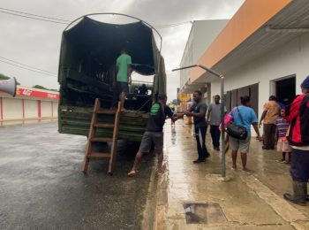 A truck is parked outside a building where people wait to be evacuated as part of the humanitarian support deployed after Tropical Cyclone Harold hit Vanuatu