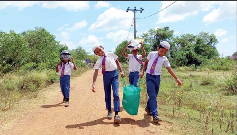 Schoolchildren in Mutur, Trincomalee come back from school with food rations for their families and supplies donated by A-PAD SL in partnership with HSBC