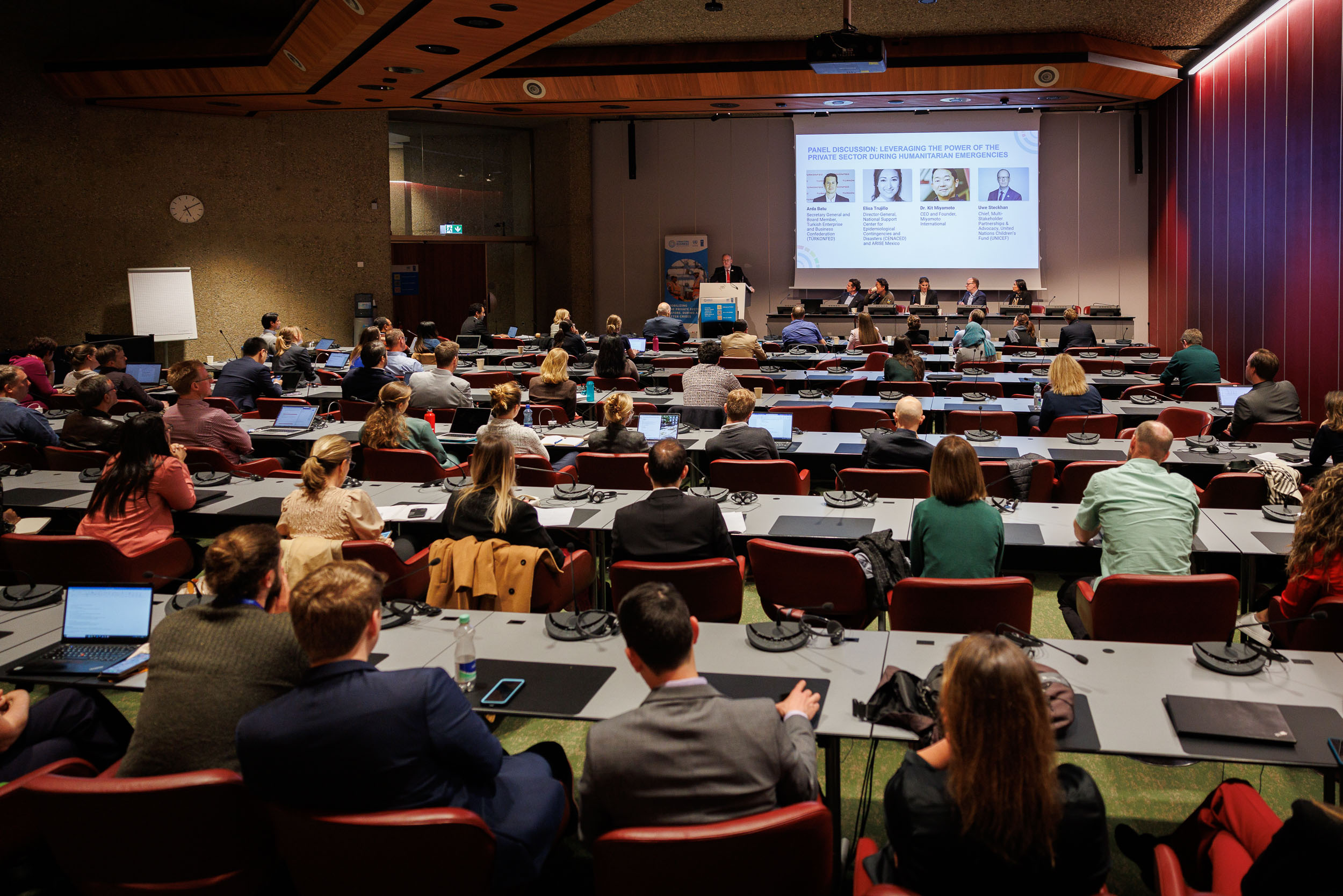 A series of speakers are on stage talking about disaster management in front of a room full of people at HNPW
