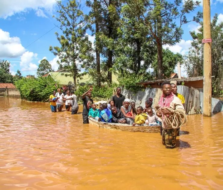 A family uses a boat after fleeing floodwaters that wreaked havoc in the Githurai area of Nairobi, Kenya, April 24, 2024. © 2024 AP Photo/Patrick Ngugi, File